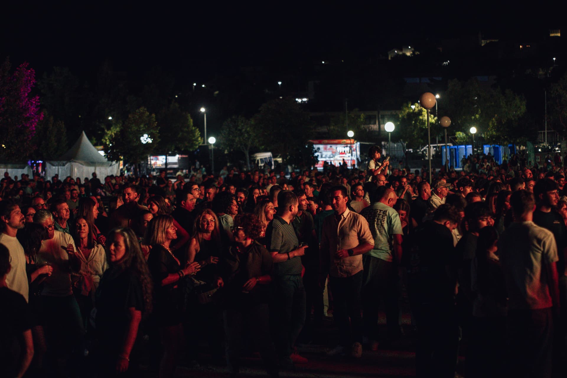 Recinto da feira repleto de participantes à noite