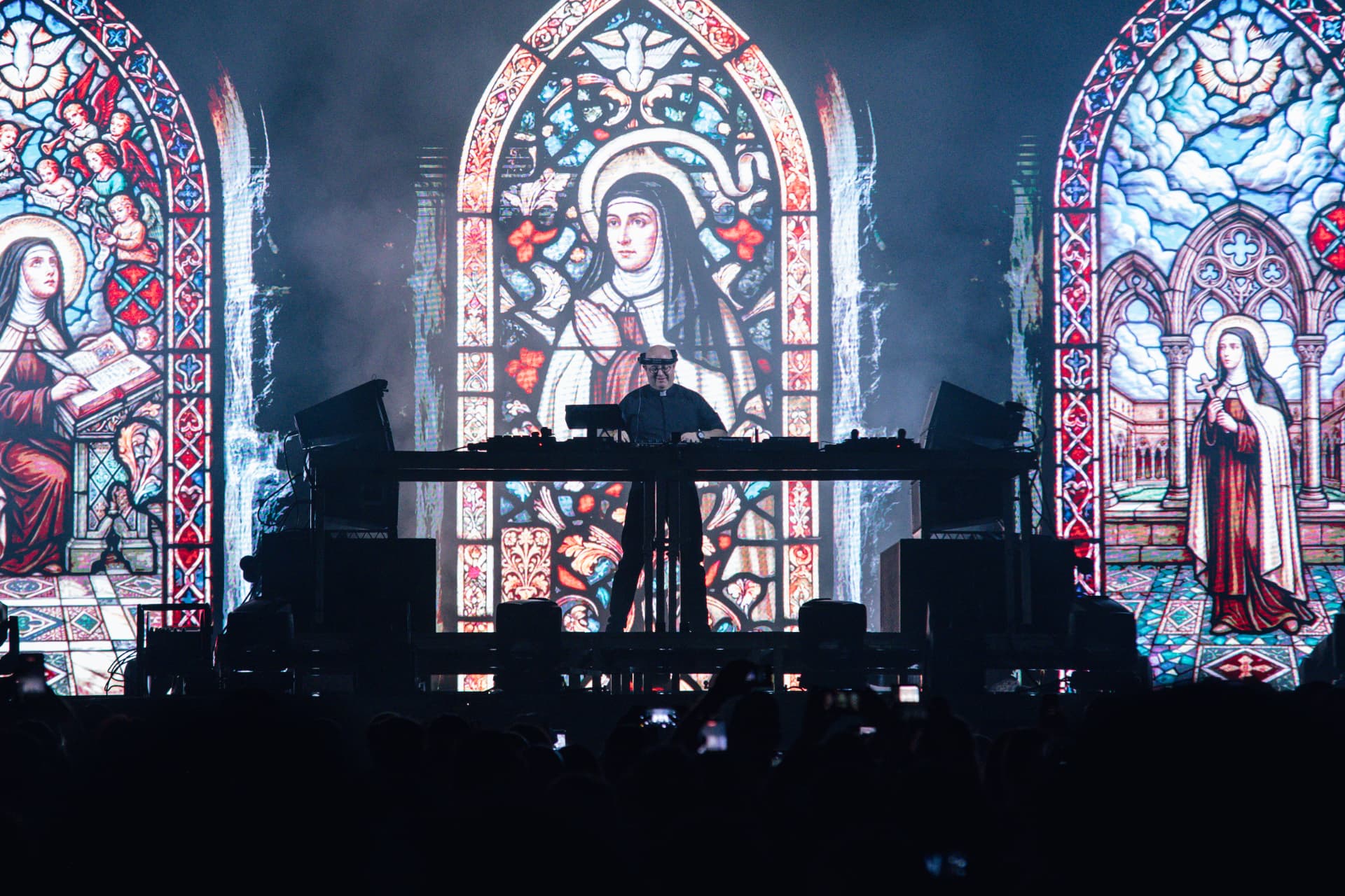 Padre Guilherme diante de vitrais de Santa Teresa projetados