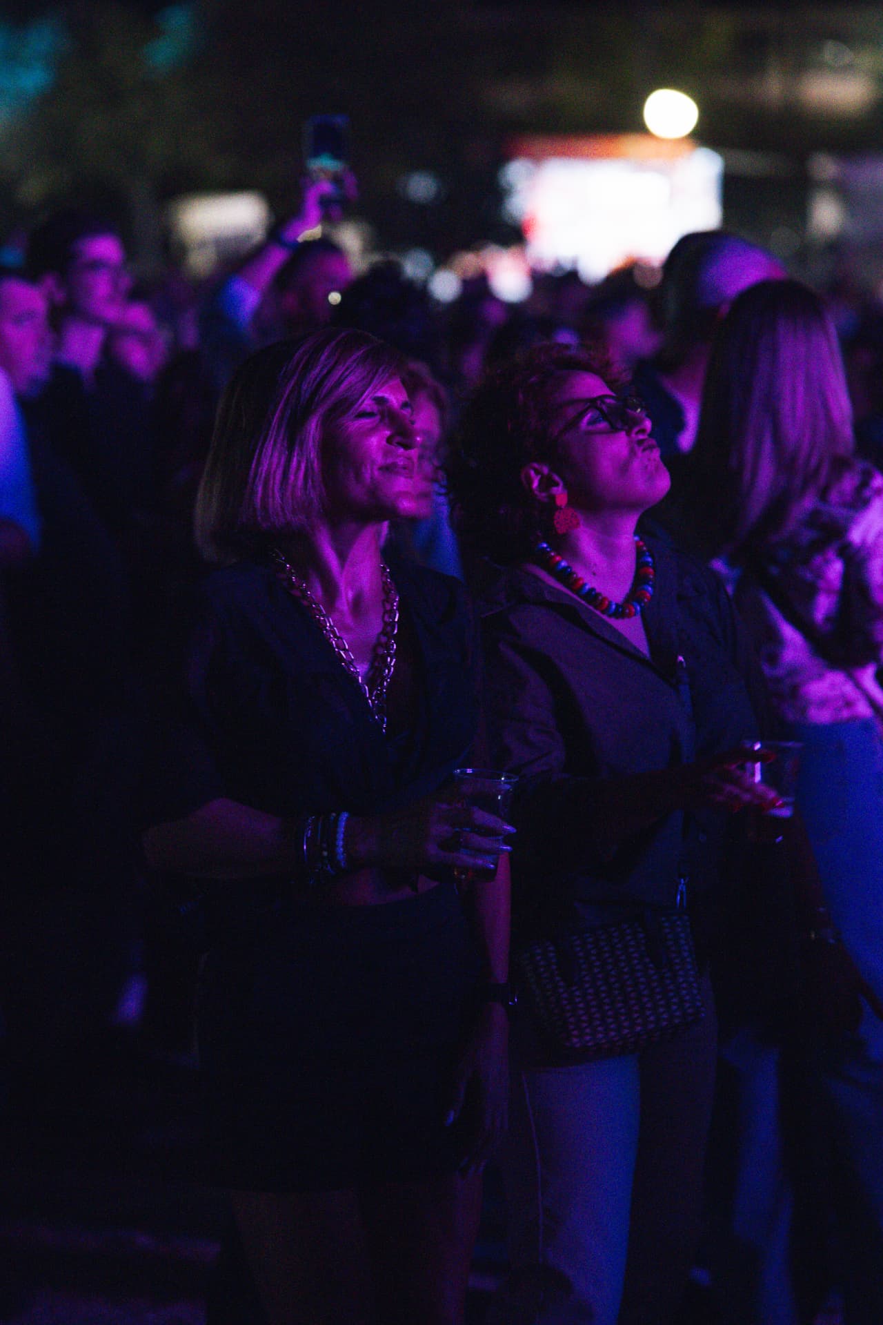 Participantes de olhos no palco sob luz violeta