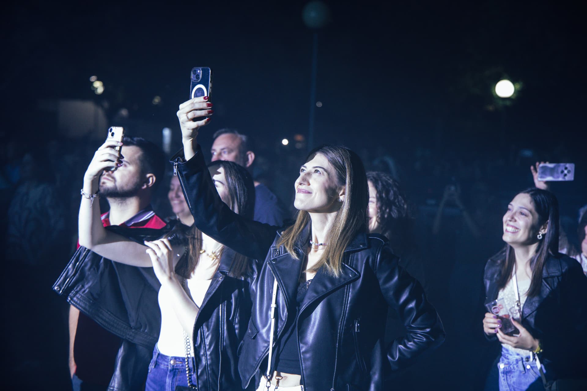 Participantes fotografam o palco com os telemóveis durante a noite