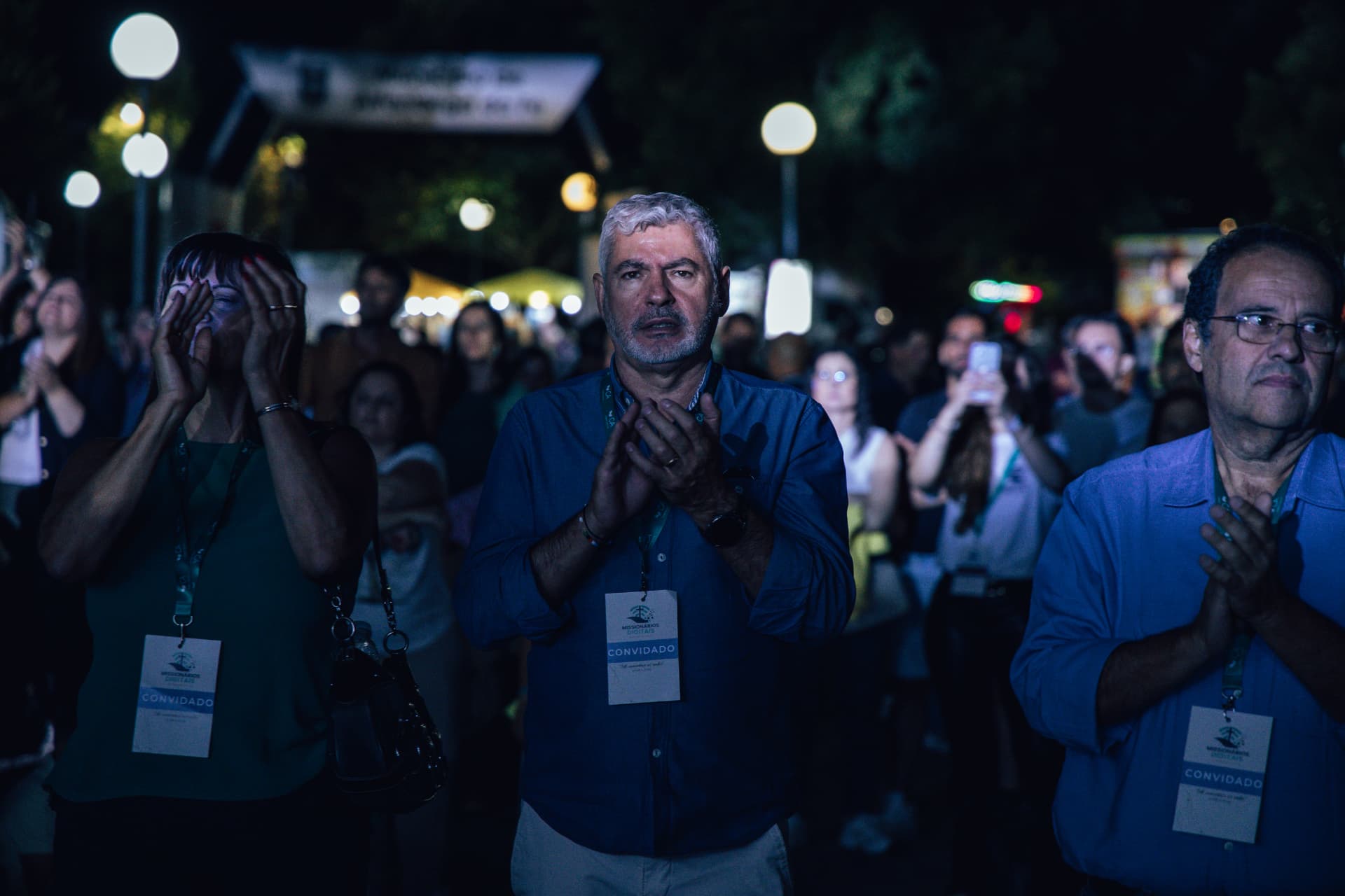 Convidados com cartões de credenciamento rezam no recinto à noite