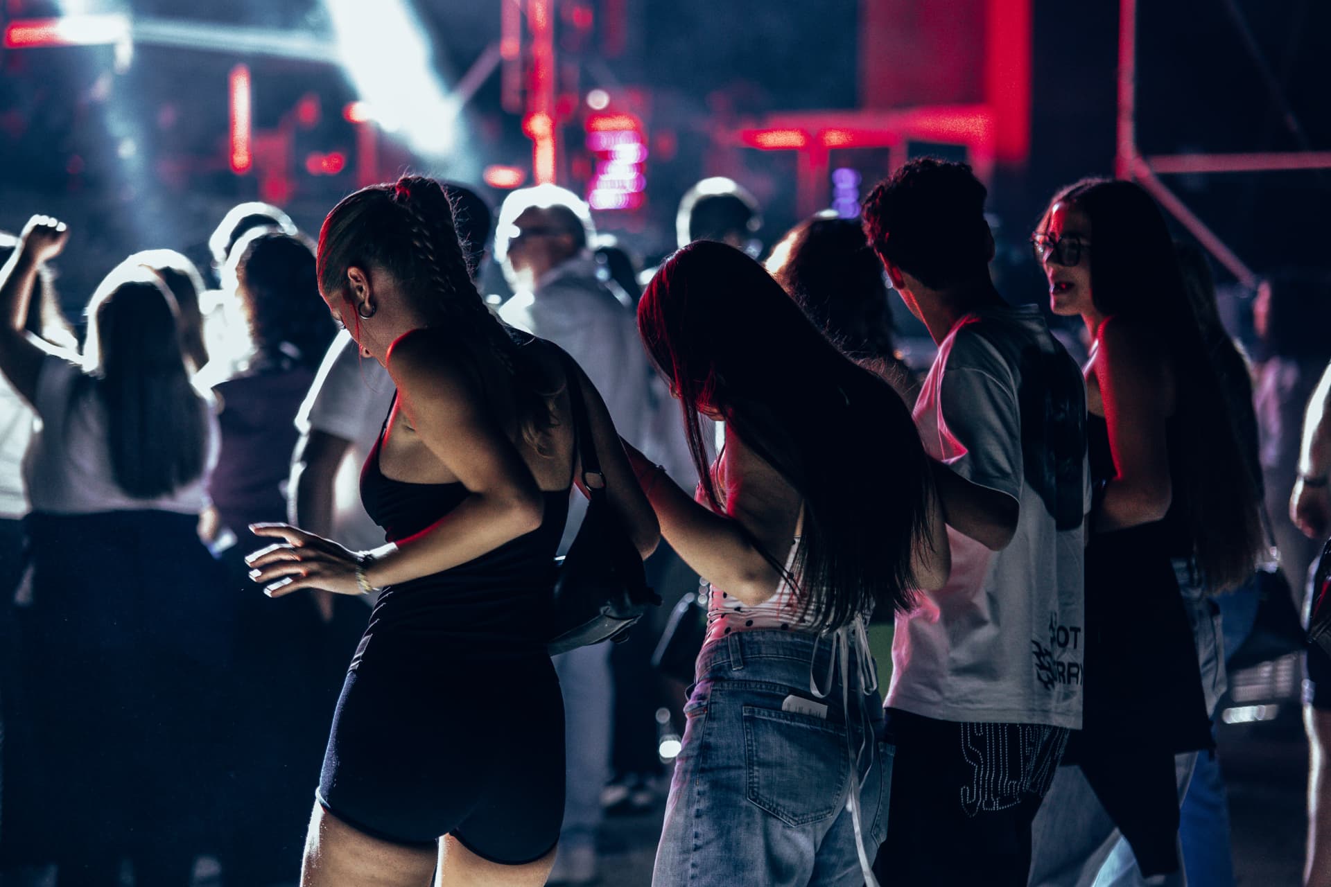 Grupo de jovens a dançar junto ao palco iluminado