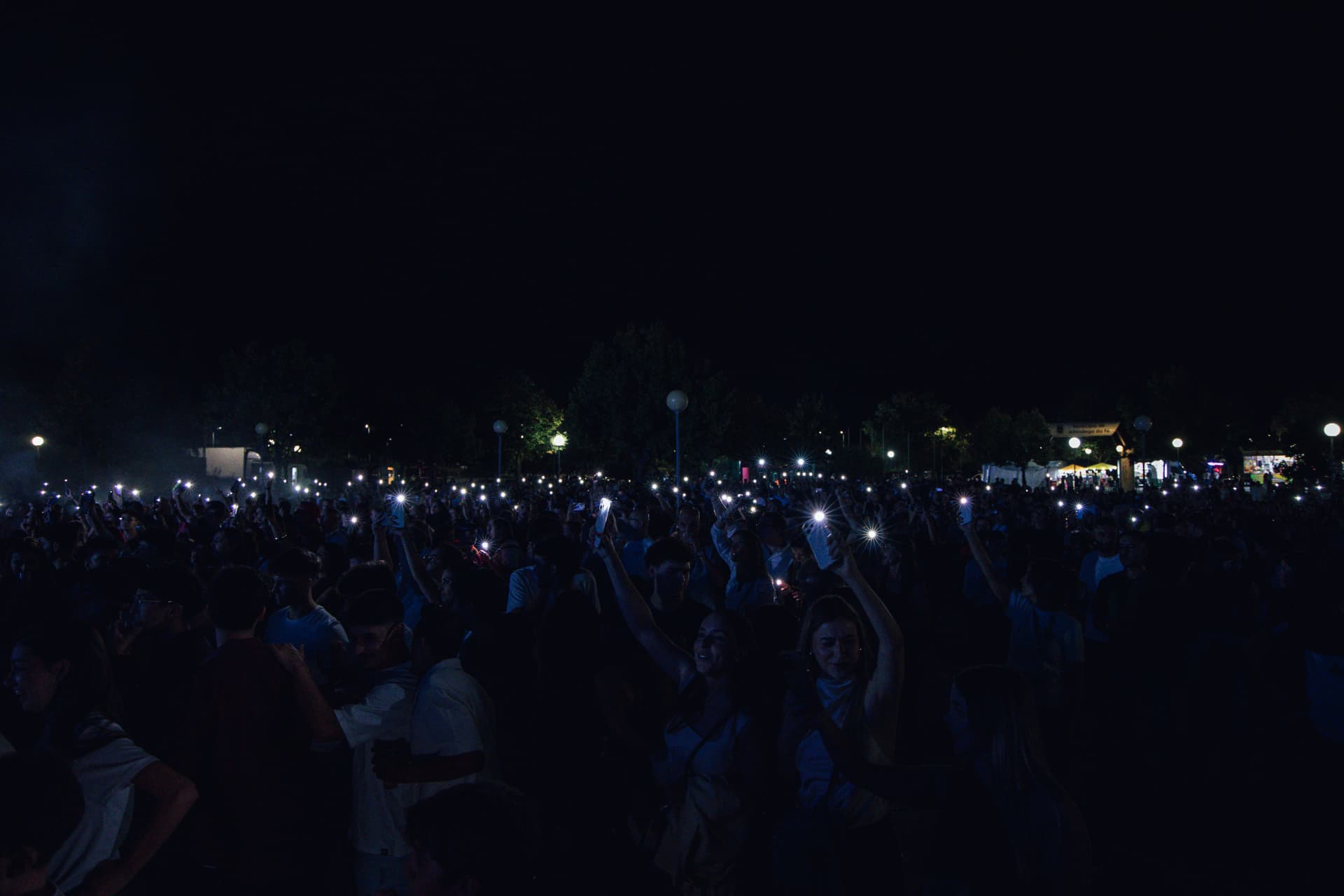 Multidão no recinto com luzes de telemóveis acesas