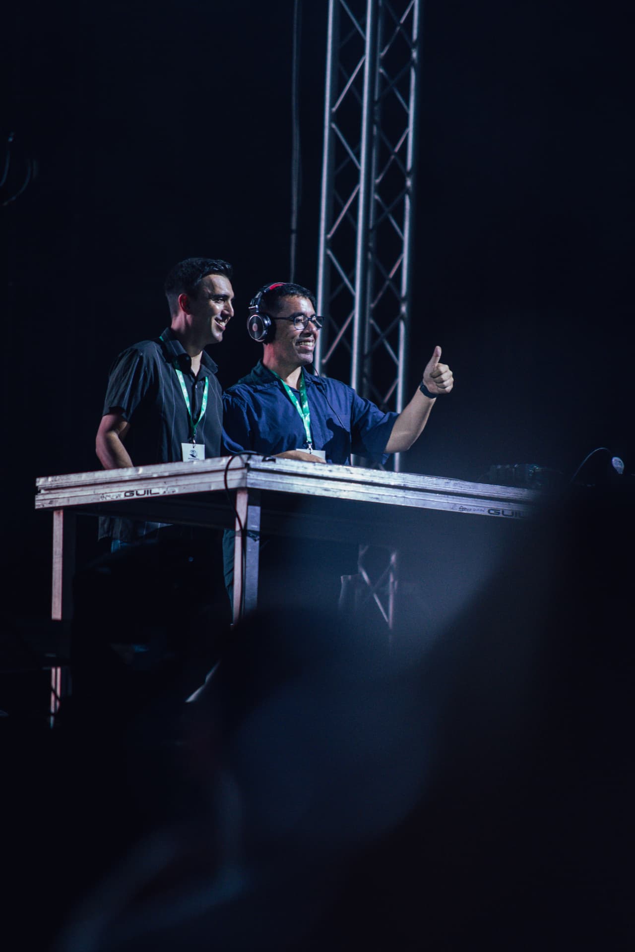 DJs sorridentes fazem sinal de positivo ao público
