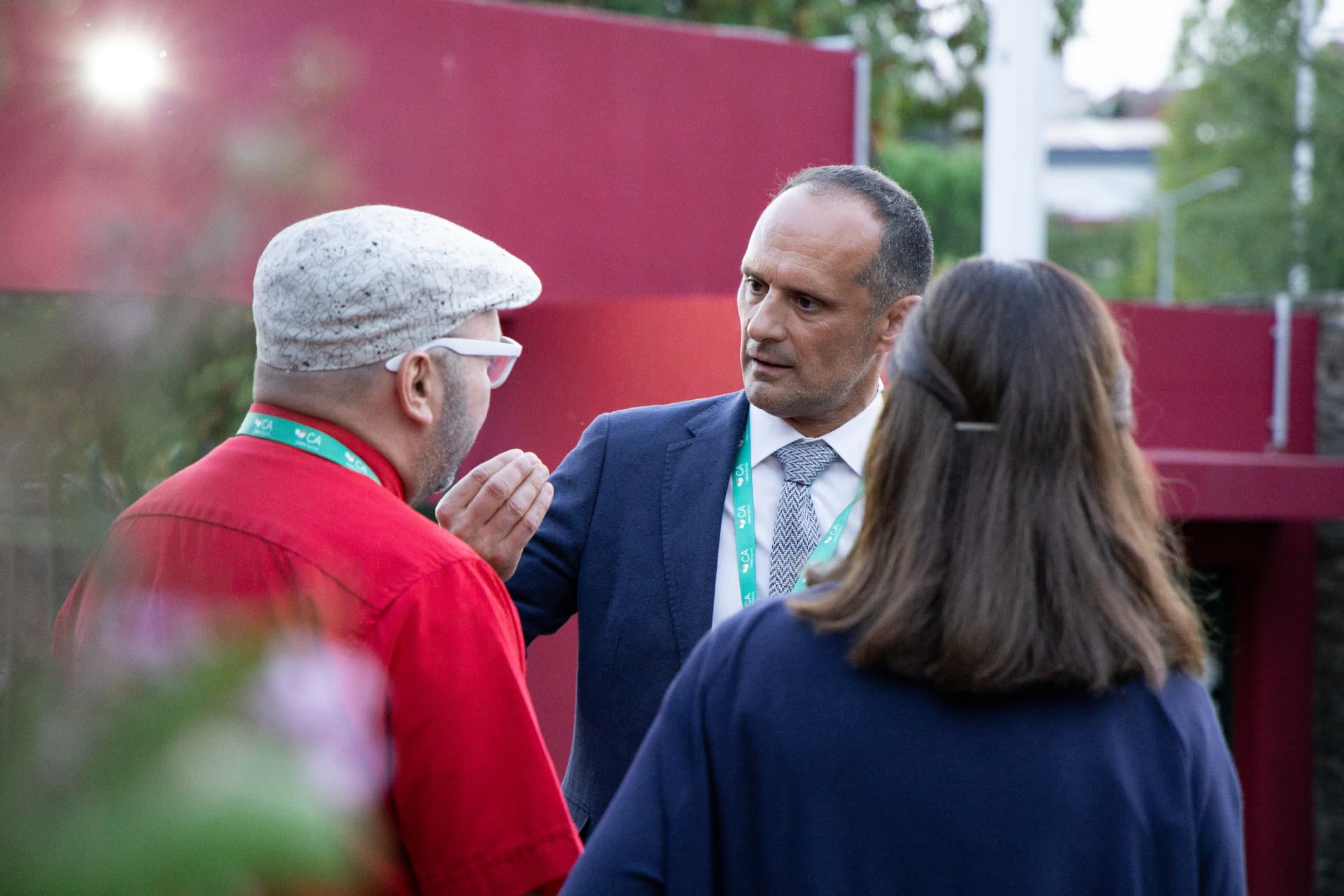 Participantes com cordões verdes conversam junto ao recinto