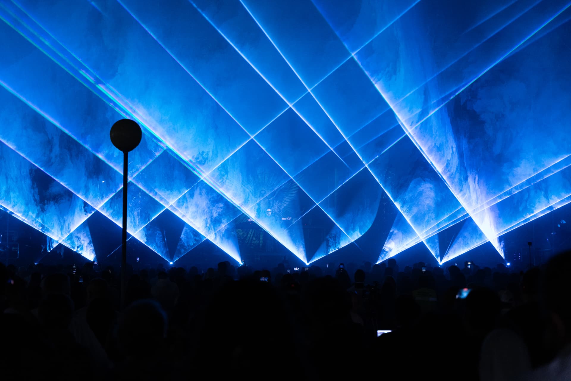 Leque de lasers azuis sobre a multidão