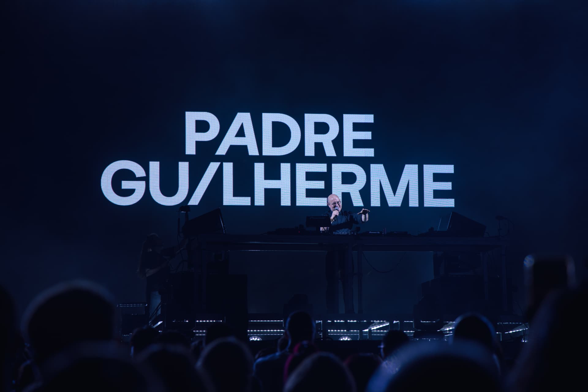 Padre Guilherme no palco diante do grande ecrã com o seu nome