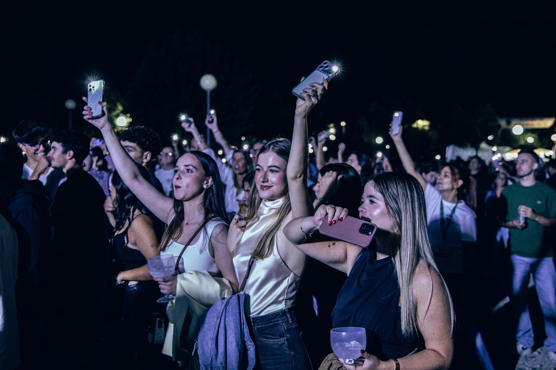 Participantes com telemóveis iluminados no recinto