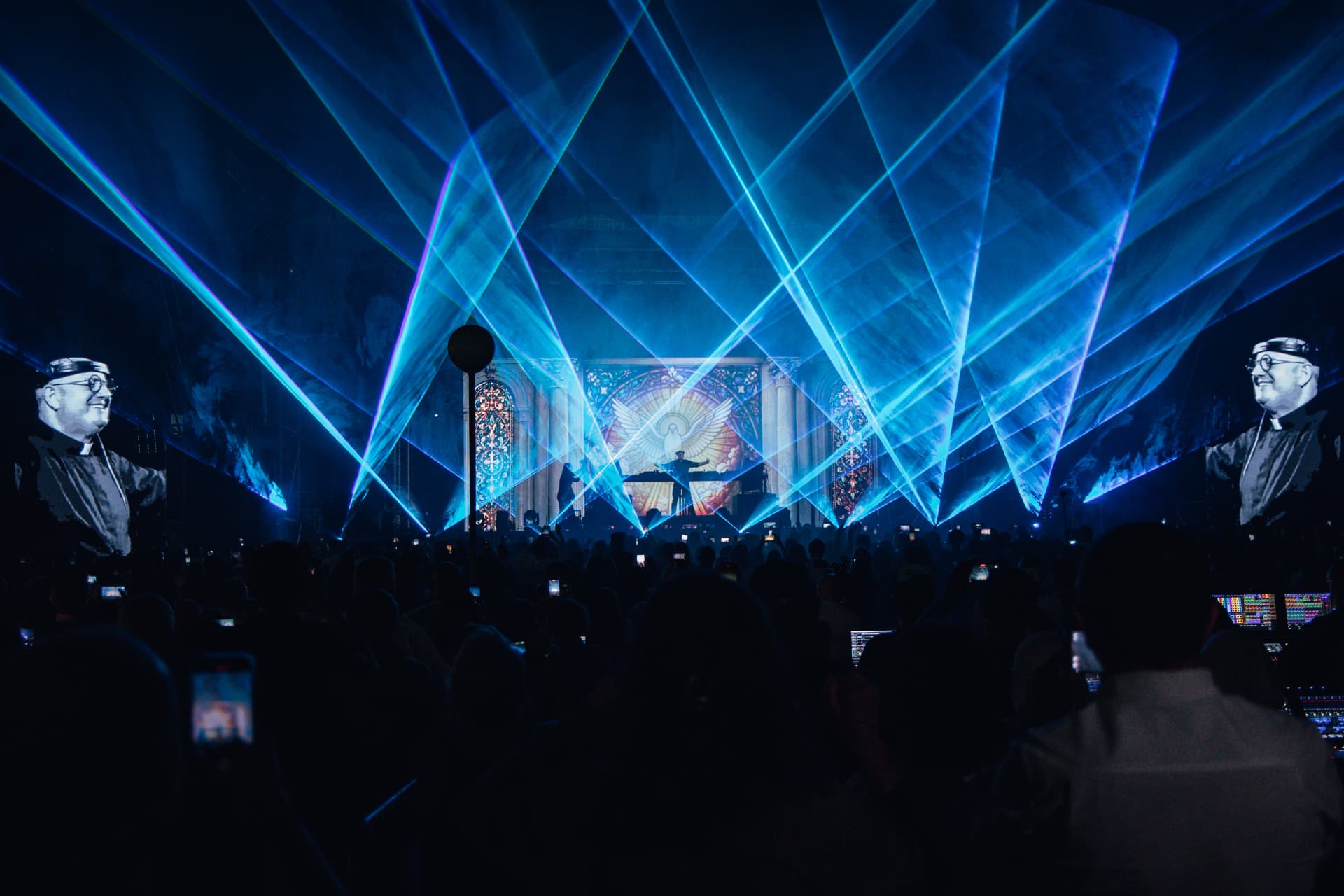 Lasers azuis sobre o palco com o Padre Guilherme nos ecrãs