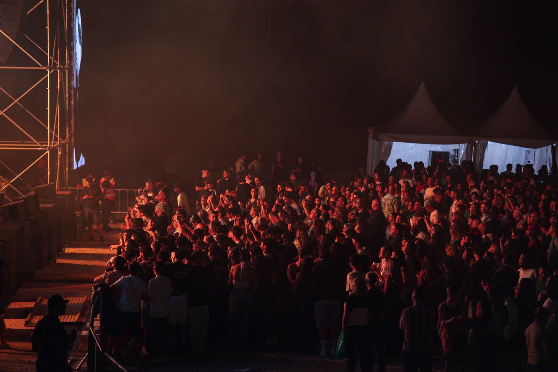 Público sob luz quente junto ao palco