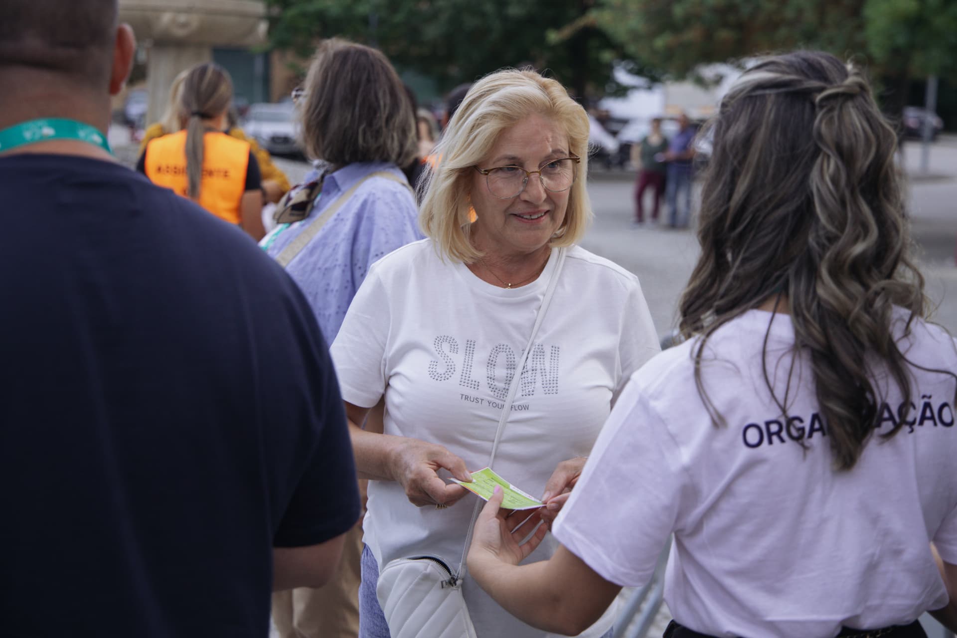 Participante recebe o bilhete na bilheteira do recinto