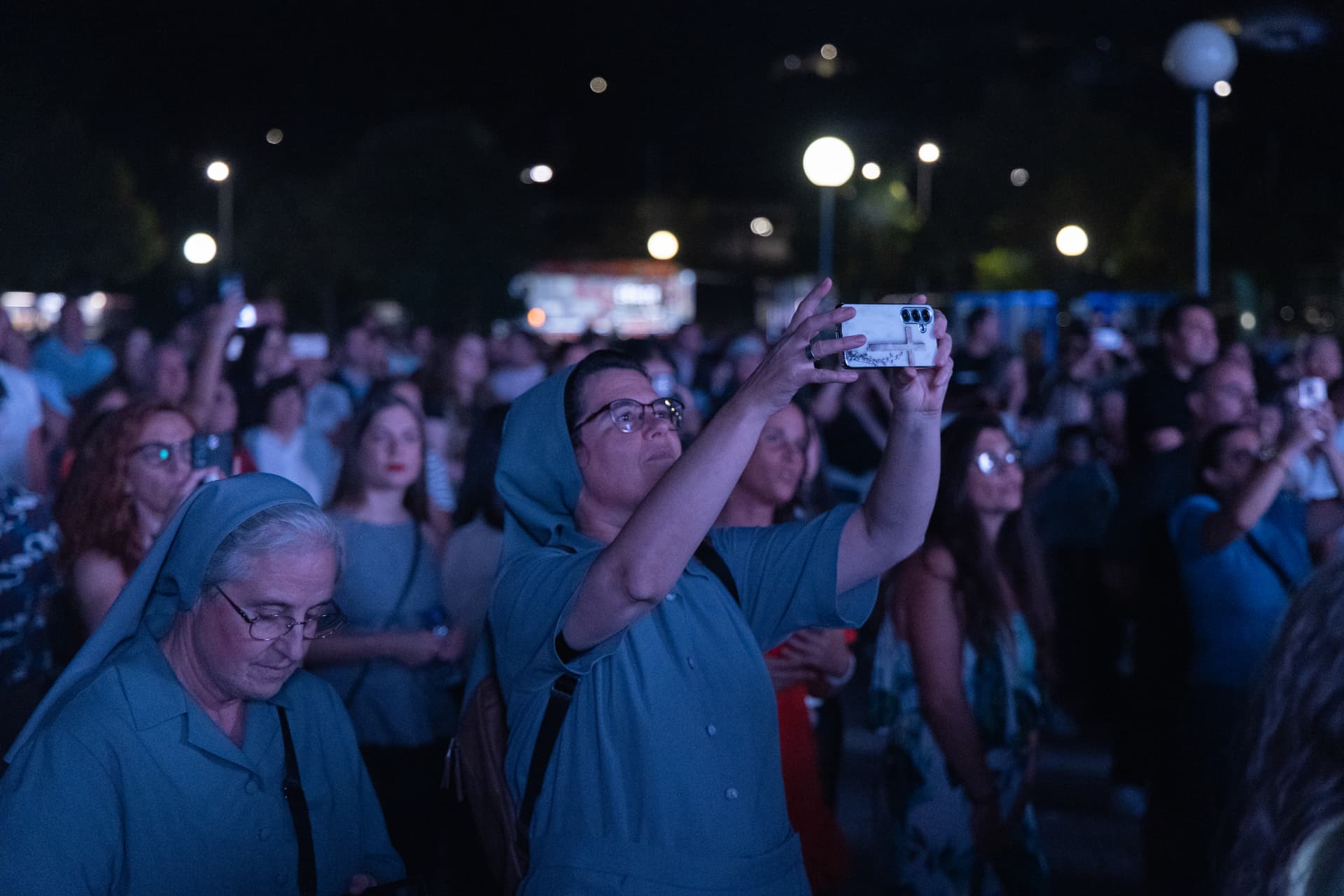 Duas religiosas junto ao recinto durante a noite