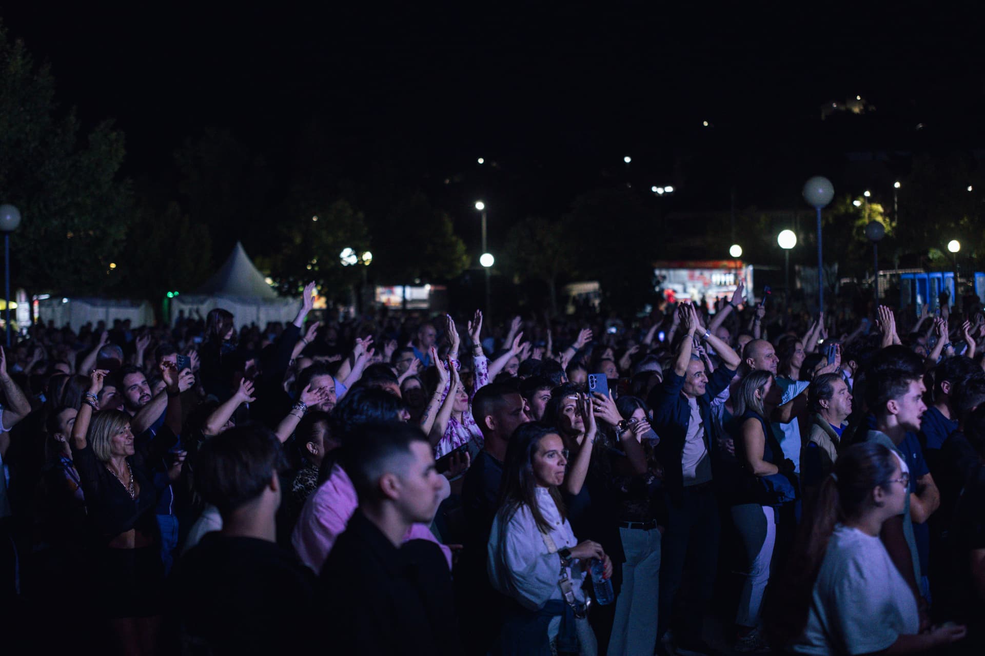 Participantes aplaudem e filmam o concerto