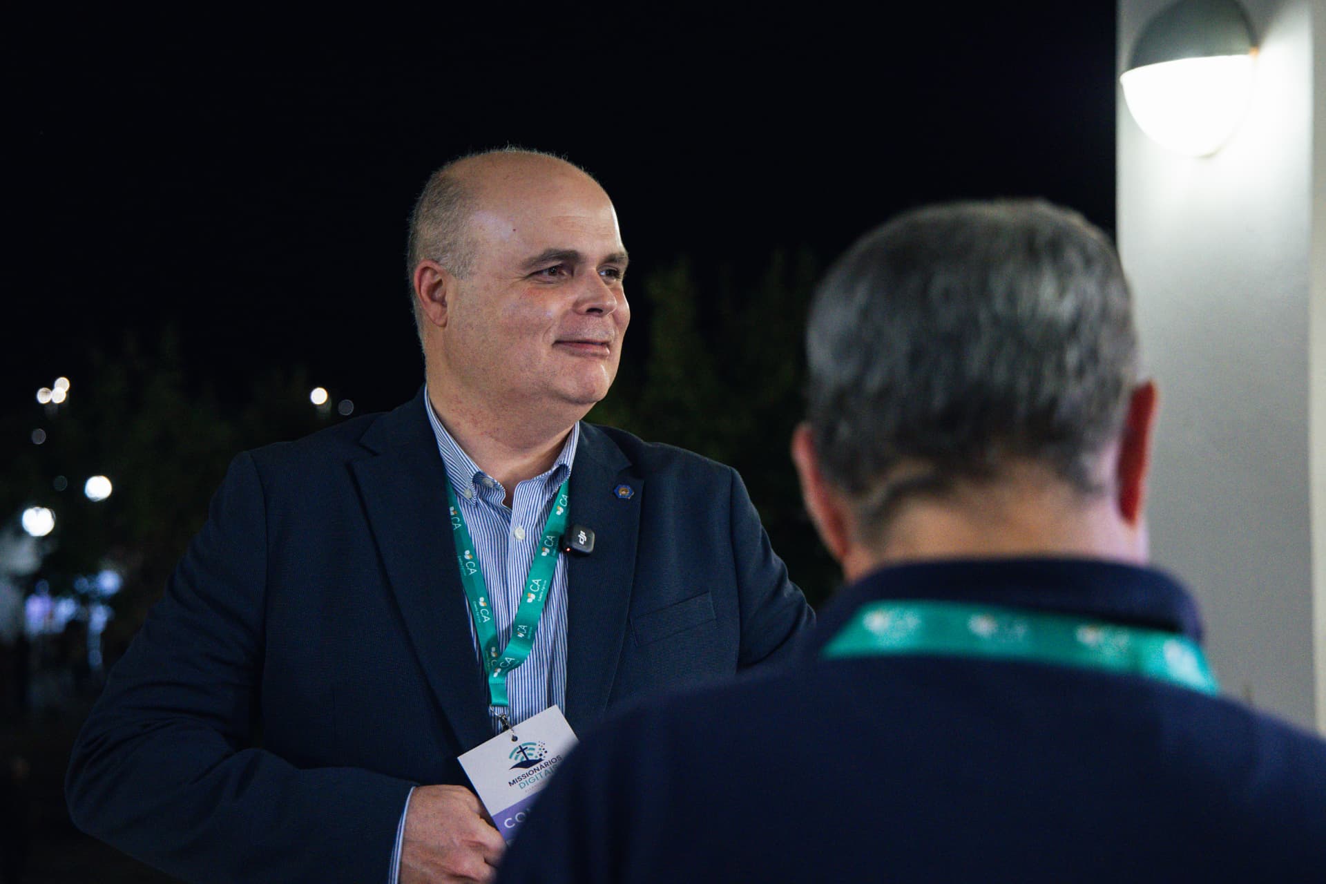 Convidado com credencial conversa no recinto durante a noite