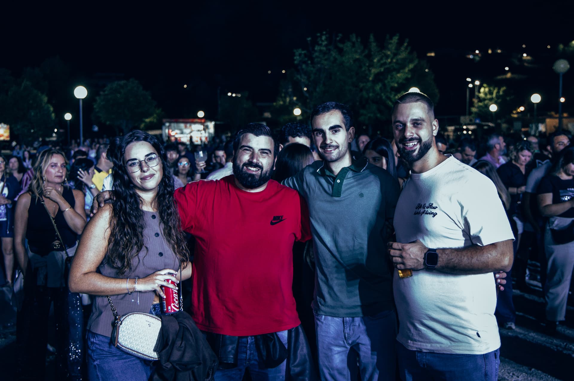 Grupo de amigos posa para uma fotografia durante a noite no recinto