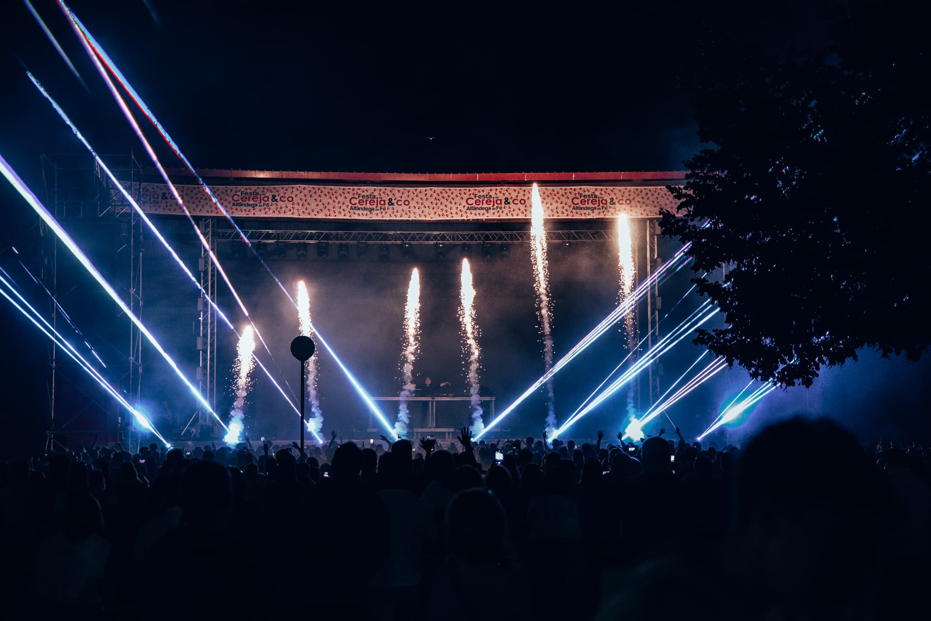 Público com braços levantados diante do palco iluminado