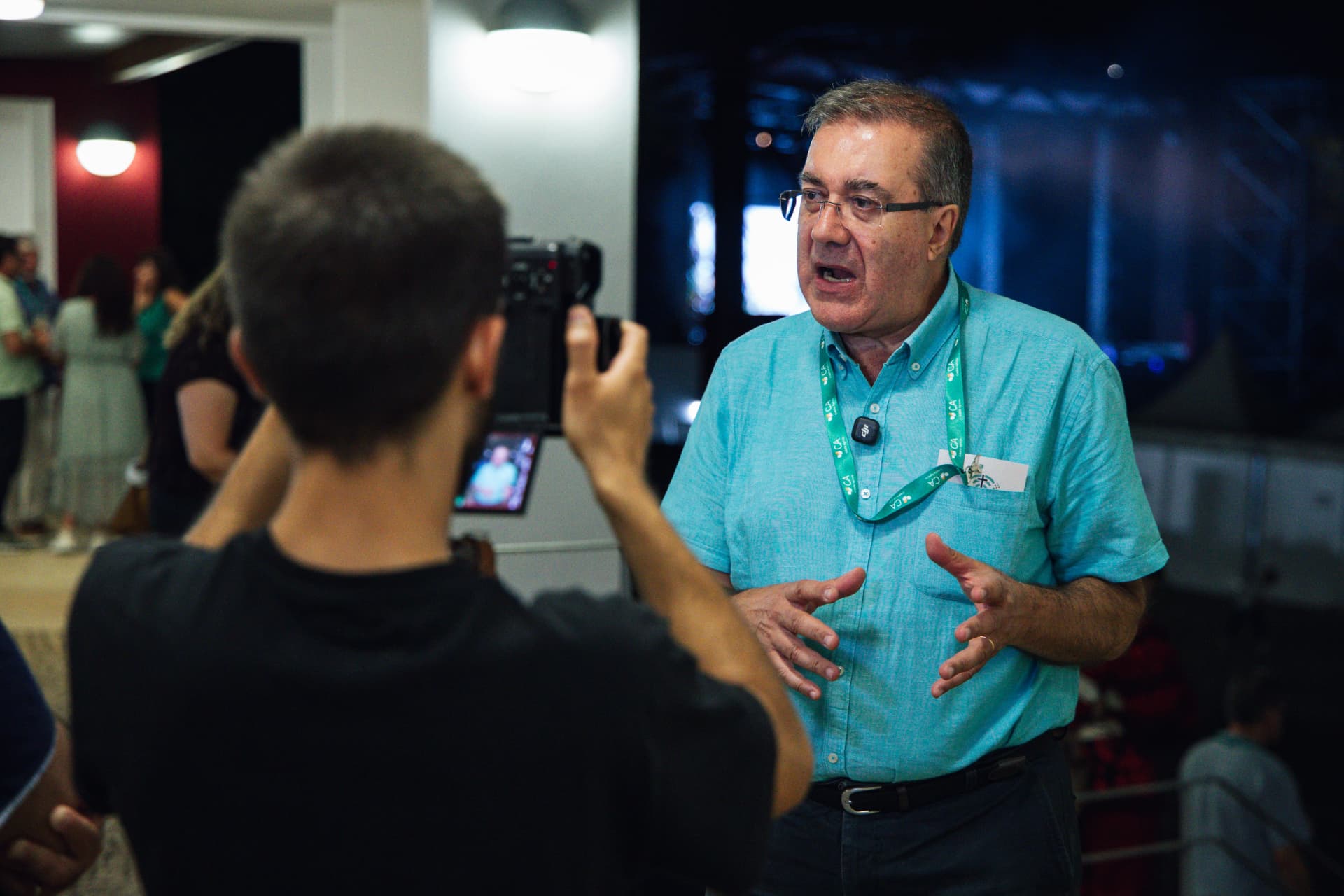 Sacerdote continua a entrevista ao jornalista junto às vitrinas